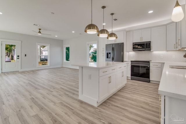 kitchen with white cabinetry, pendant lighting, a kitchen island, and appliances with stainless steel finishes