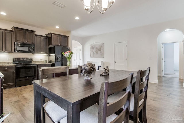 dining area with light wood-style floors, visible vents, arched walkways, and recessed lighting