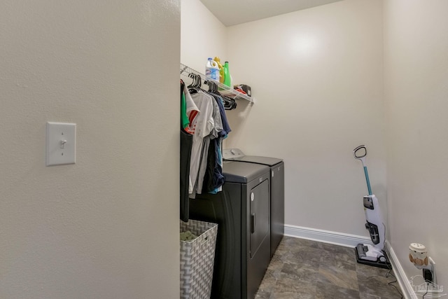 washroom featuring laundry area, washing machine and dryer, and baseboards