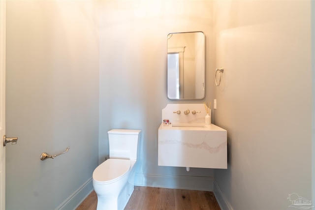 bathroom featuring hardwood / wood-style flooring and toilet