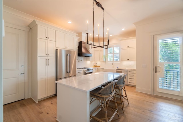 kitchen featuring a breakfast bar area, white cabinetry, premium appliances, a kitchen island, and custom exhaust hood