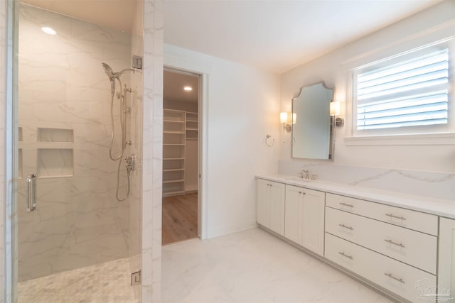 bathroom with vanity and a shower with door