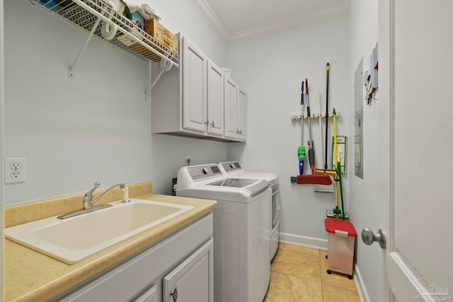 washroom with ornamental molding, sink, cabinets, light tile patterned floors, and washing machine and clothes dryer