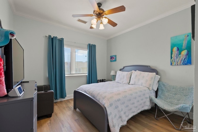 bedroom with ornamental molding, ceiling fan, and light wood-type flooring