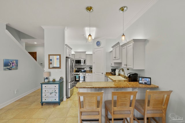 kitchen featuring decorative light fixtures, kitchen peninsula, sink, appliances with stainless steel finishes, and light tile patterned floors