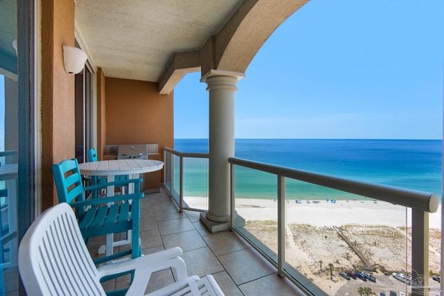 balcony with a water view and a view of the beach