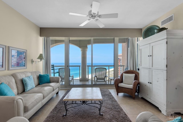 living area with ceiling fan, visible vents, a water view, and light tile patterned floors