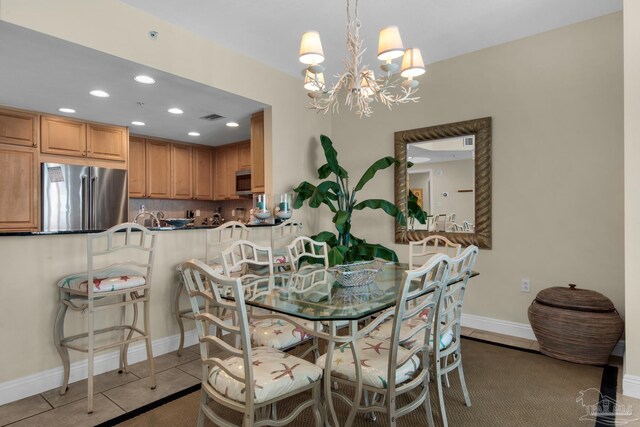 dining area featuring a notable chandelier and light tile patterned floors