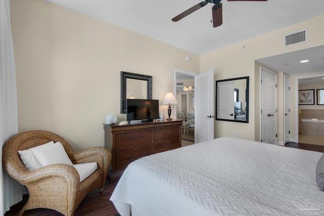 bedroom with a ceiling fan, visible vents, wood finished floors, and ensuite bathroom