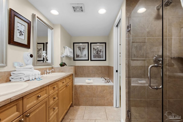 bathroom with tile patterned floors, double sink vanity, and plus walk in shower