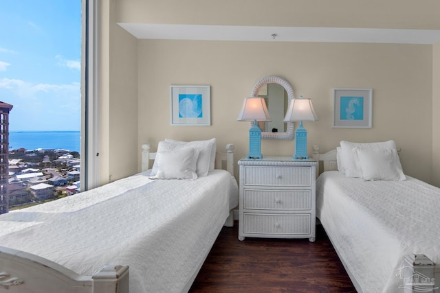 bedroom featuring a water view and wood finished floors