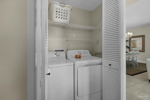 clothes washing area with laundry area, independent washer and dryer, and light tile patterned flooring