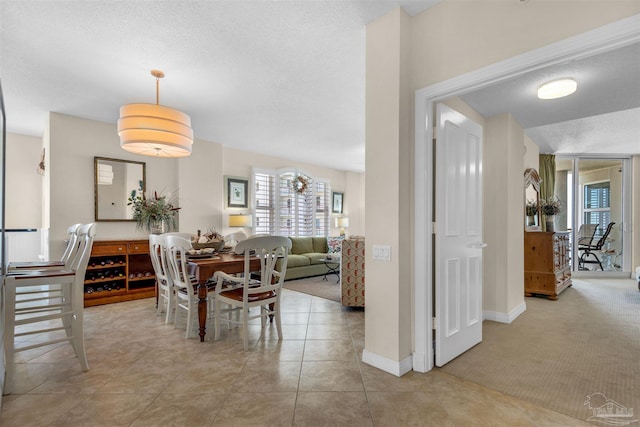 carpeted dining space featuring a textured ceiling