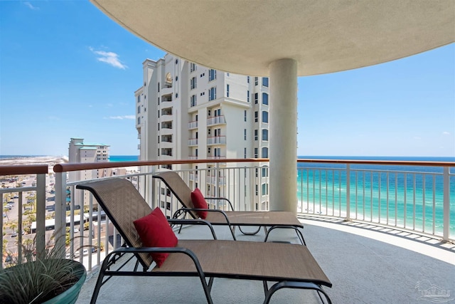 balcony with a water view and a beach view