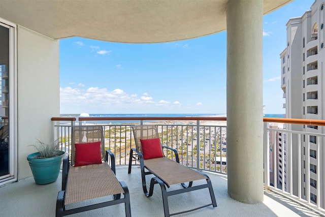 balcony featuring a water view and a view of the beach