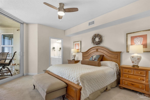 carpeted bedroom featuring ensuite bathroom, ceiling fan, and a textured ceiling