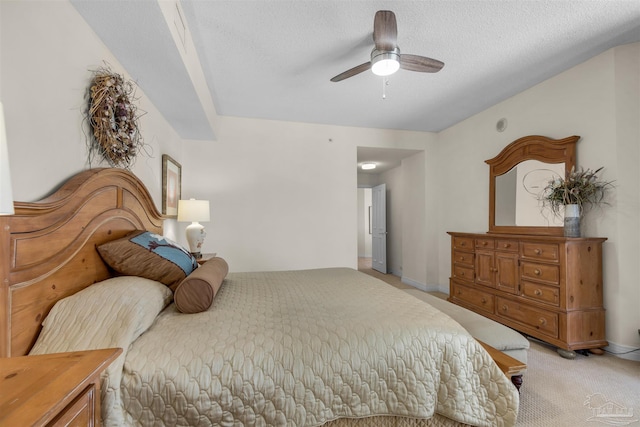 carpeted bedroom featuring ceiling fan and a textured ceiling