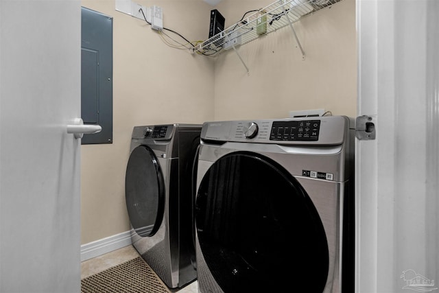 clothes washing area with independent washer and dryer, tile patterned floors, and electric panel