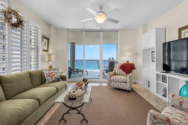 living room with expansive windows, ceiling fan, and a textured ceiling