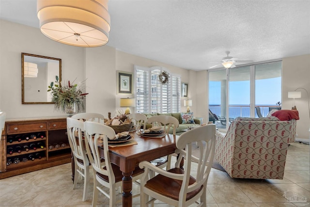 tiled dining area with ceiling fan and a textured ceiling