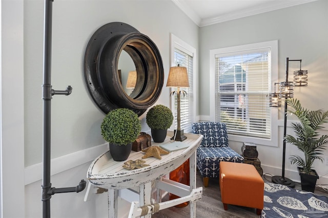 living area with baseboards, crown molding, and wood finished floors