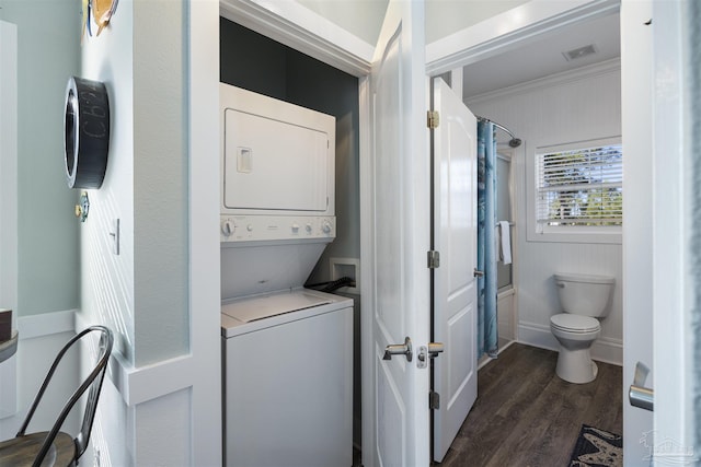 washroom featuring laundry area, visible vents, dark wood finished floors, ornamental molding, and stacked washing maching and dryer