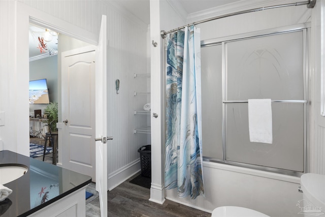 bathroom featuring combined bath / shower with glass door, ornamental molding, wood finished floors, and toilet