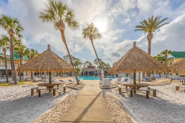 view of property's community featuring a swimming pool, a gazebo, and fence