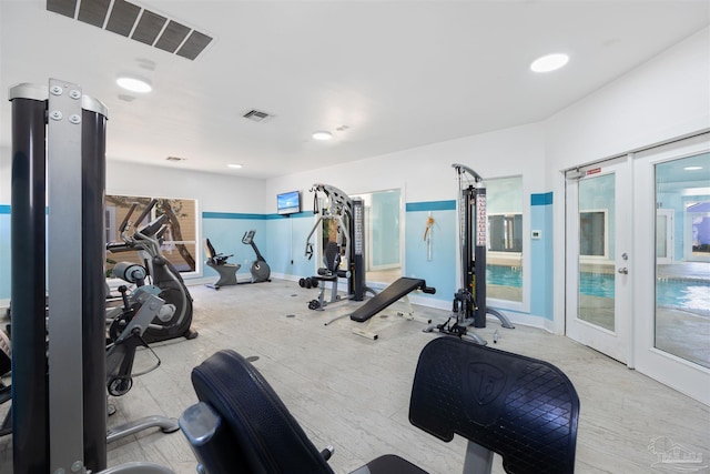 workout area with french doors, wood finished floors, and visible vents