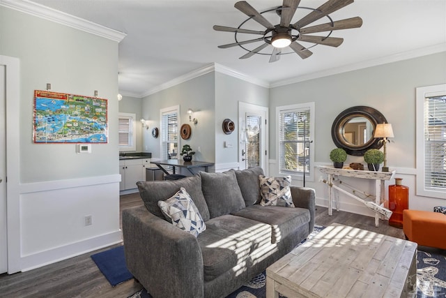 living room with crown molding, a ceiling fan, dark wood-style flooring, and a wealth of natural light