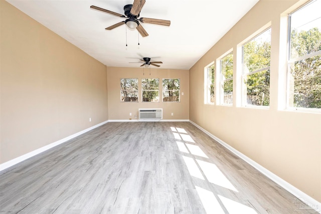 interior space with a wall mounted air conditioner, light hardwood / wood-style flooring, and ceiling fan