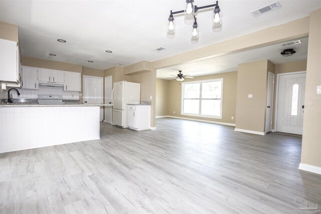 kitchen featuring white cabinets, backsplash, ceiling fan, light hardwood / wood-style floors, and white refrigerator