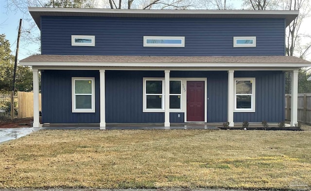 view of front of property with a front yard, covered porch, and fence