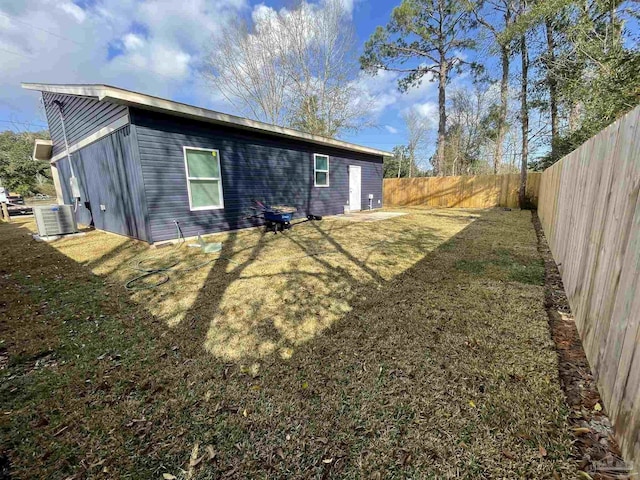 exterior space featuring central AC unit, a yard, and a fenced backyard