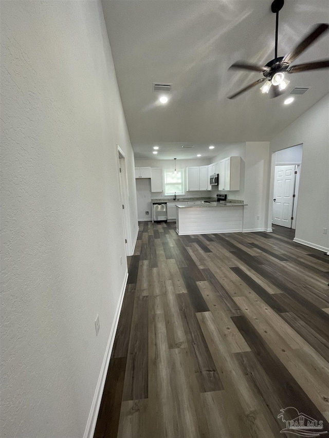 unfurnished living room with dark hardwood / wood-style floors and ceiling fan