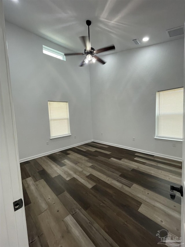 spare room with visible vents, dark wood finished floors, ceiling fan, and baseboards