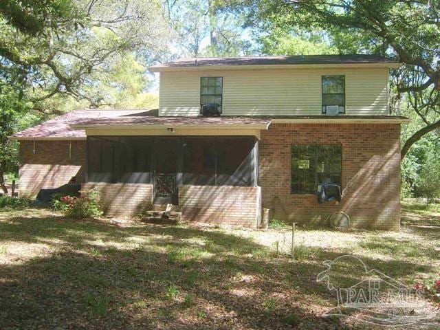 back of property featuring a yard and a sunroom