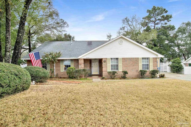 ranch-style house featuring brick siding, a shingled roof, and a front yard