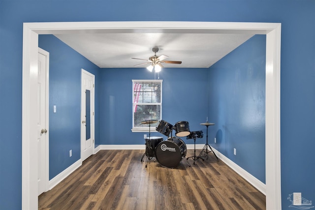 living area featuring a ceiling fan, baseboards, and wood finished floors