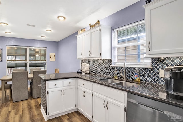 kitchen with visible vents, white cabinets, dishwasher, a peninsula, and a sink