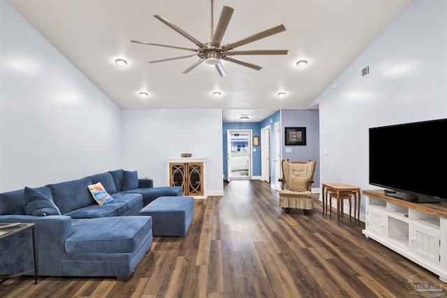 living area featuring dark wood-style floors, vaulted ceiling, a ceiling fan, and baseboards