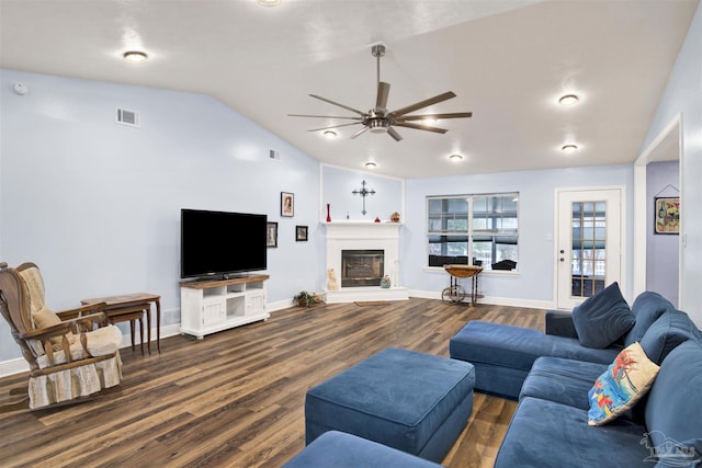 living room with lofted ceiling, wood finished floors, visible vents, a ceiling fan, and a glass covered fireplace