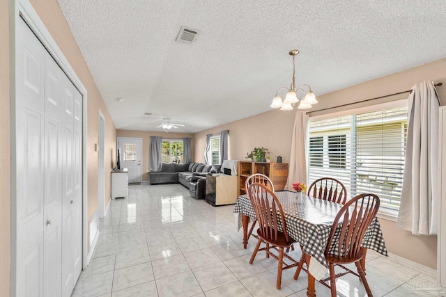 dining space featuring light tile patterned floors, visible vents, a textured ceiling, baseboards, and ceiling fan with notable chandelier