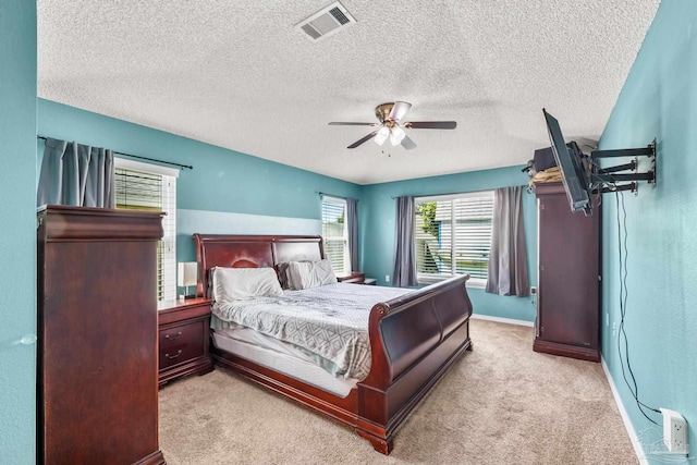 bedroom featuring ceiling fan, visible vents, baseboards, and light colored carpet