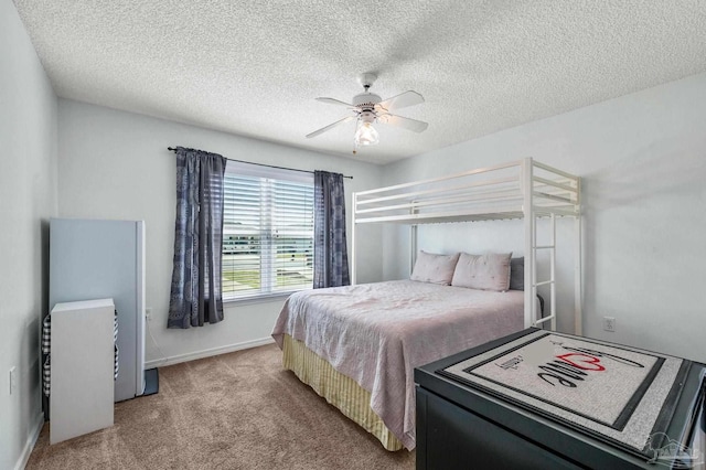 bedroom featuring ceiling fan, baseboards, a textured ceiling, and light colored carpet