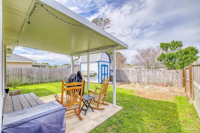 view of yard with an outbuilding, a shed, a patio area, and a fenced backyard