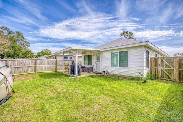 back of house with a patio, a lawn, a fenced backyard, and a gate