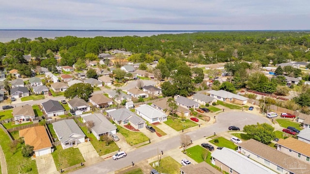 drone / aerial view with a water view, a residential view, and a view of trees