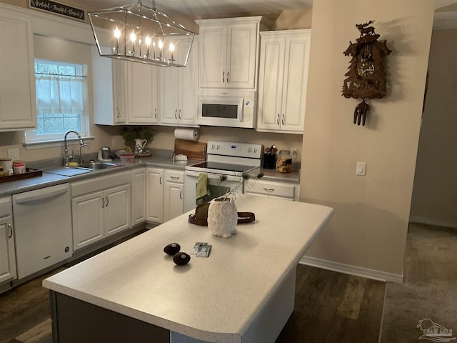 kitchen featuring white appliances, a sink, white cabinetry, baseboards, and dark wood finished floors