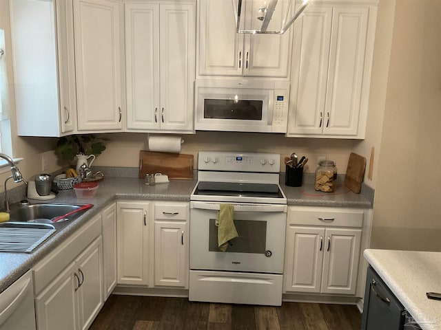 kitchen featuring white appliances, dark wood-type flooring, a sink, and white cabinets